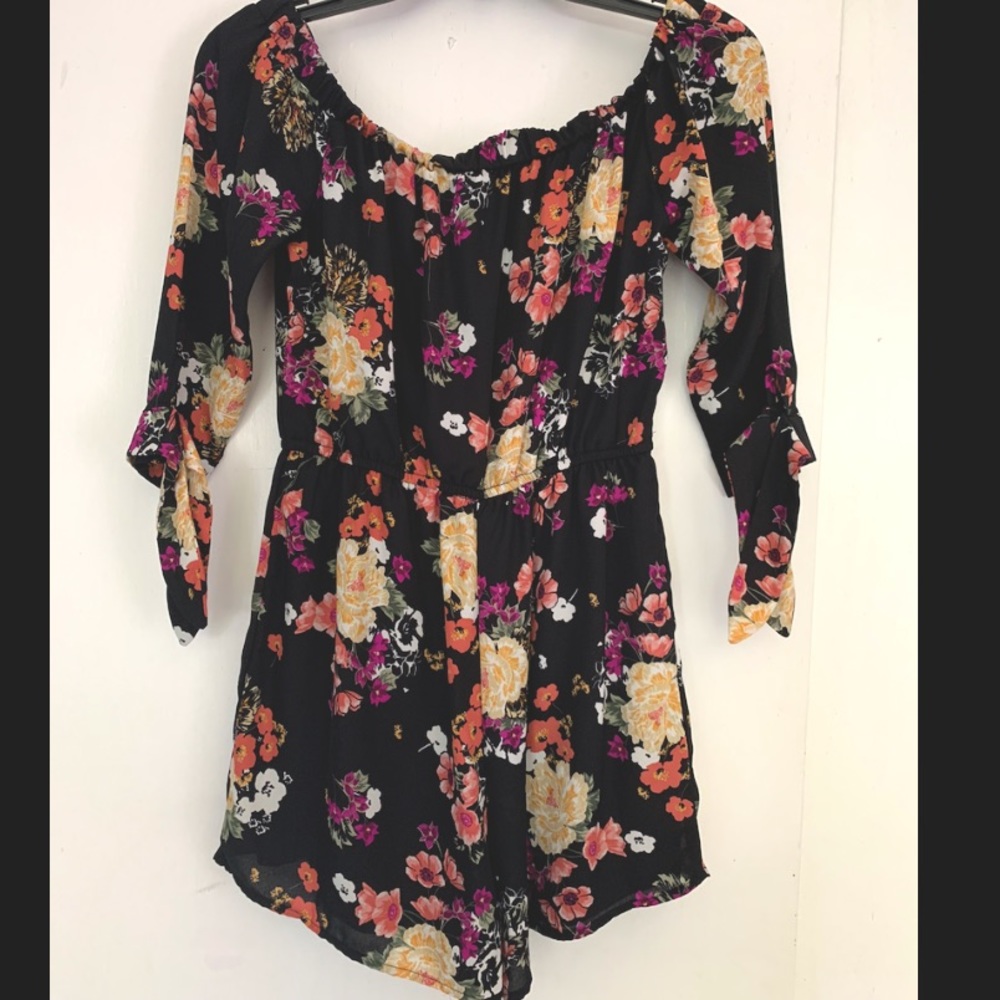 Short black romper with purple, white, yellow, peach flowers.